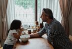 Father and daughter at kitchen table with a breakfast bowl