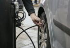 Person in black long sleeve shirt holding black metal bar near black tire