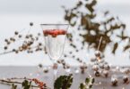 A Festive Holiday Cocktail in a Tall Glass with Holly and Decorations