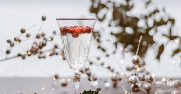 A Festive Holiday Cocktail in a Tall Glass with Holly and Decorations