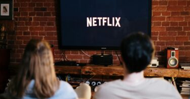 Man and woman sitting on a couch in front of a television