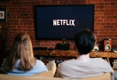 Man and woman sitting on a couch in front of a television