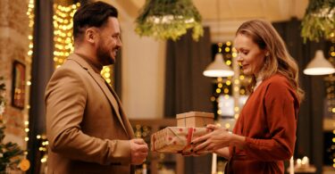 Woman giving christmas presents to her husband